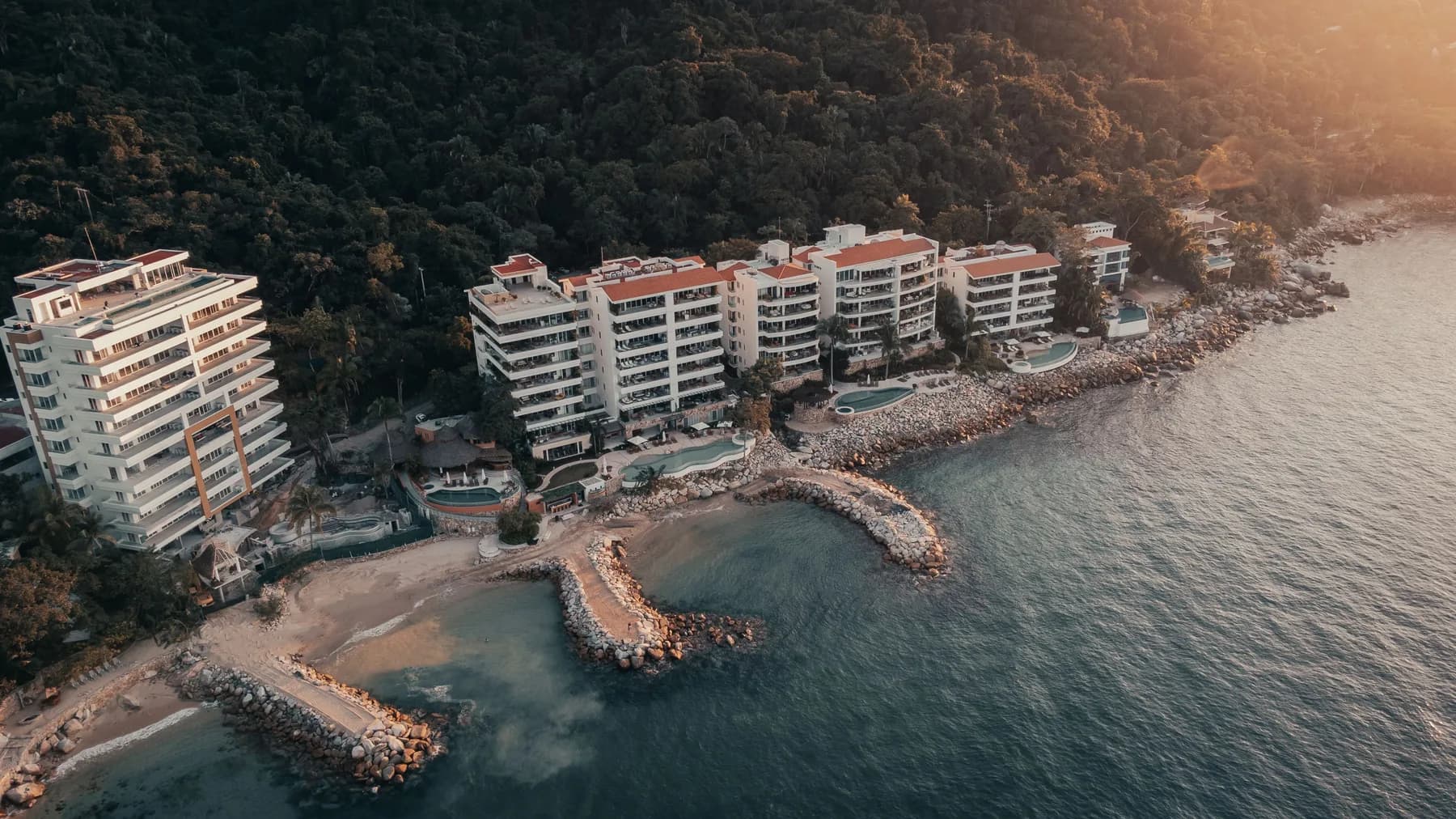 Vista aérea de condominios frente al mar al atardecer, en la costa del Pacífico